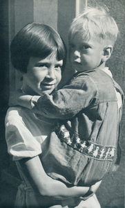 716619 Portret van een meisje met vermoedelijk haar broertje in de armen, in de Jordaan te Amsterdam.